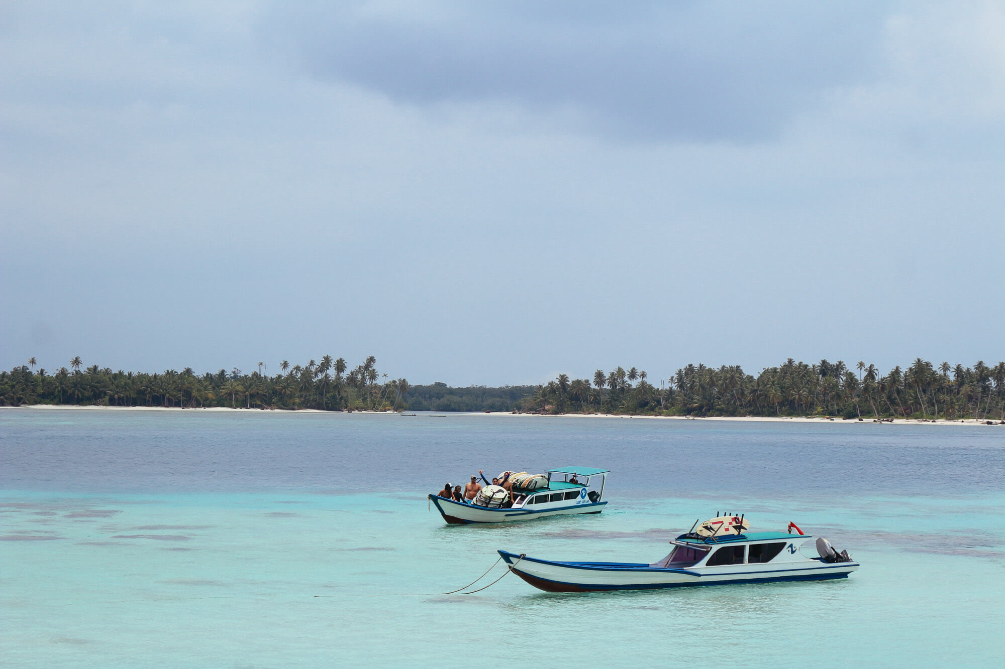 Speedboats anchored on a turquoise lagoon